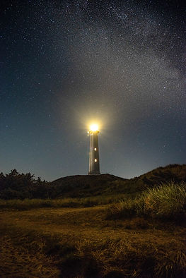 A lighthouse surrounded by rolling hills