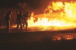 3 firefighters trying to put out a blazing fire