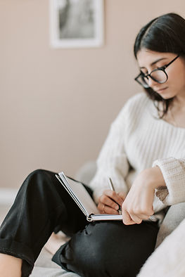 A woman writing in a journal, developing emotional intelligence.