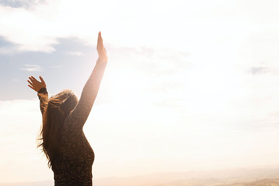 woman with arms raised in gratitude and success as she reclaims her mojo