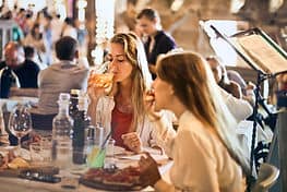 Two people in a restaurant eating and drinking