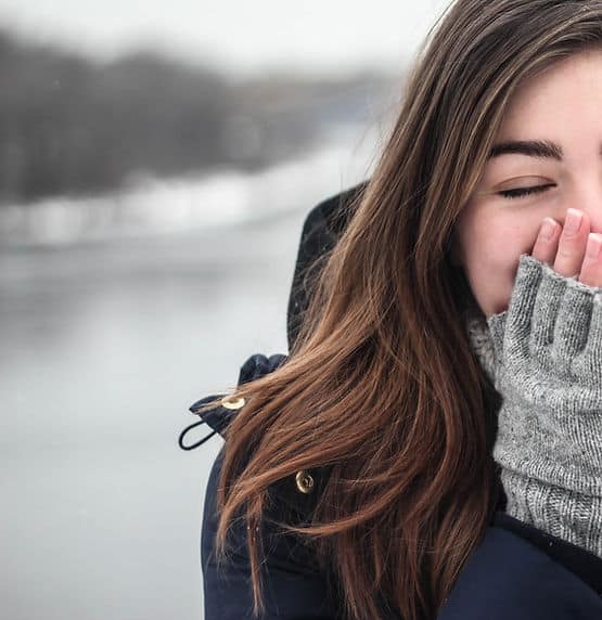 A woman with her hands over her mouth, laughing with joy