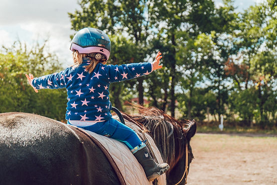 A child riding a horse with no hands