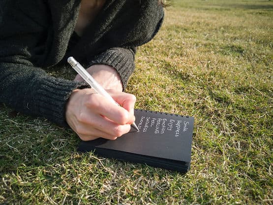 A person writing in a journal and making a list of possible new words for the new year