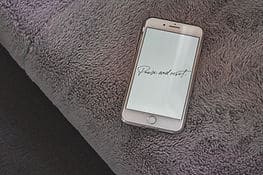 A phone with the display that reads "Pause and reset"- a key to learning how to feel more motivated.
