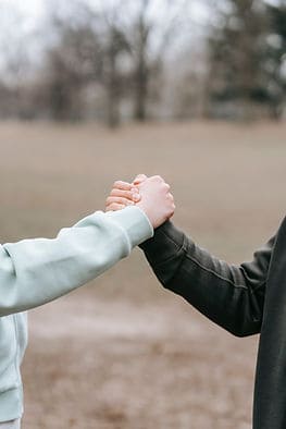 supportive handshake between coach and client