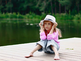 A little girl sitting on a dock