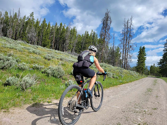 Dr. Kori climbing a mountain on her gravel bike, enjoying food freedom and exercise