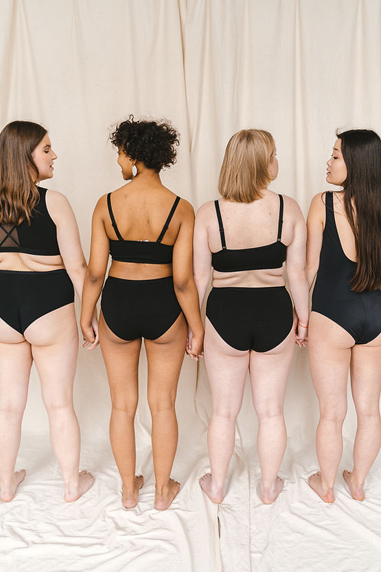 Four women with very different bodies holding hands in solidarity.