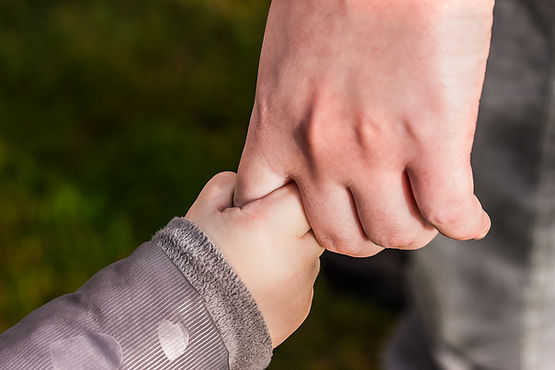 A big person's hand holding a little person's hand