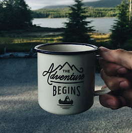 A mug with the phrase, "The adventure begins" on it