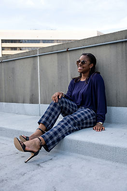A woman leaning against a wall smiling to herself